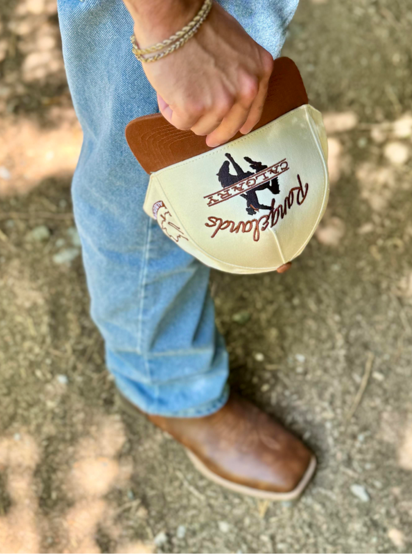 Cowboy wearing boots holding the Highwayman Hat