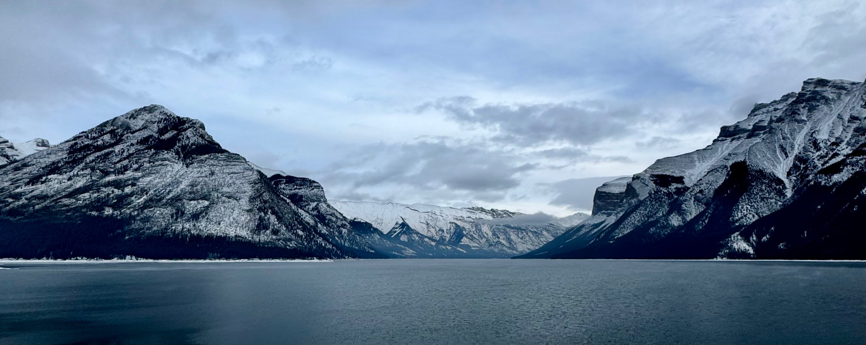Panoramic view of a mountain range with a lake in the foreground