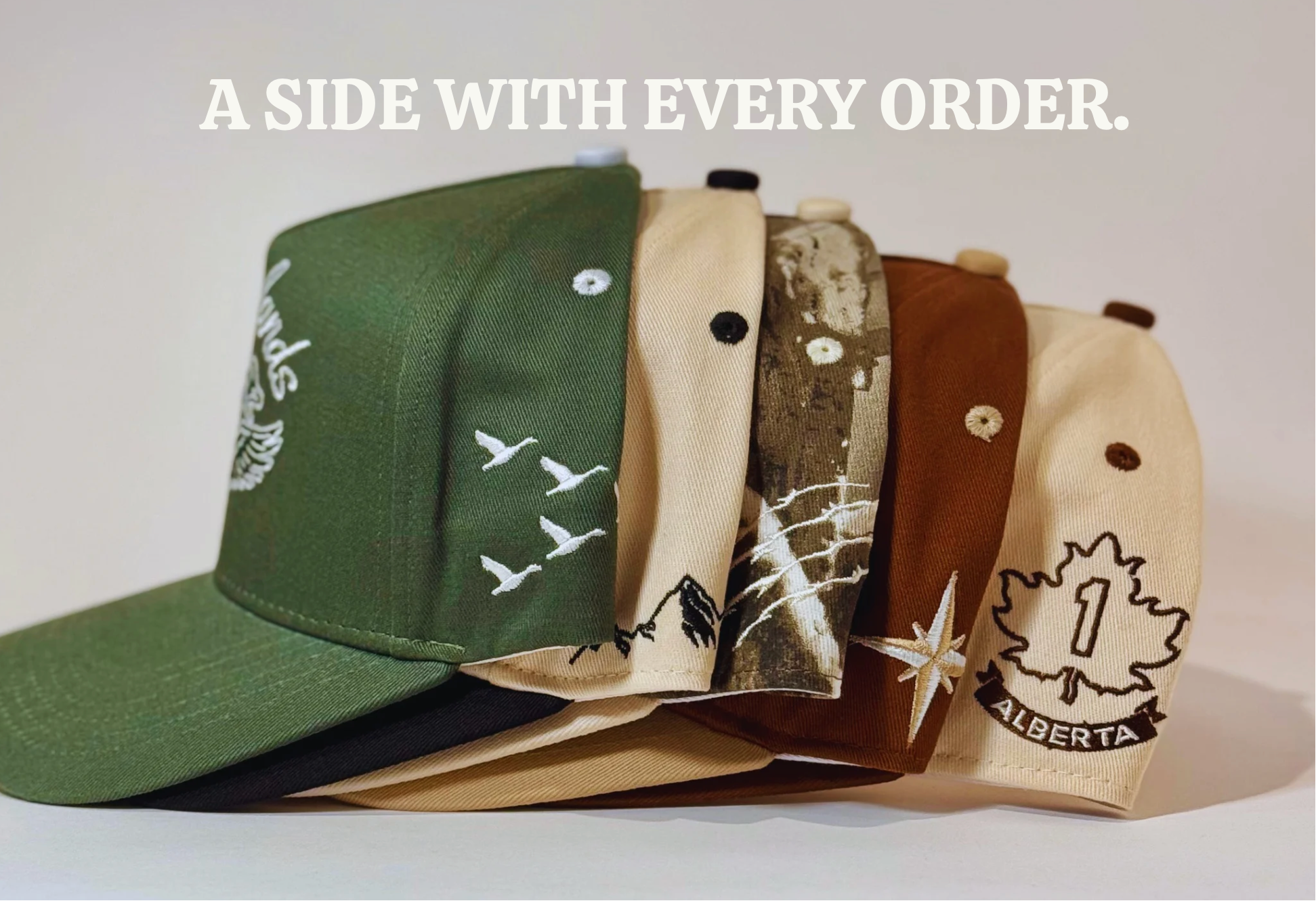 Stack of baseball caps with various designs on a white background